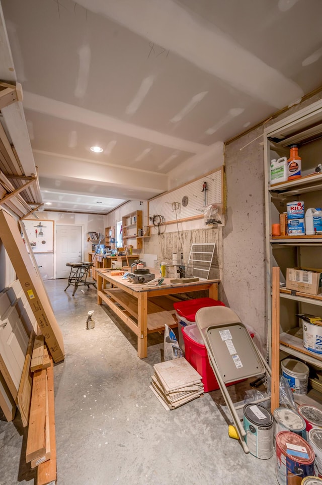 miscellaneous room featuring a workshop area and concrete flooring