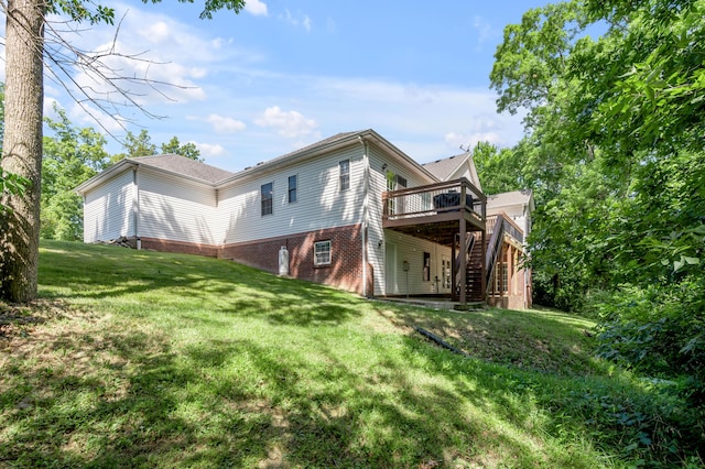 back of property with a deck and a yard