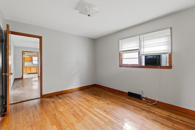 unfurnished room with cooling unit, light wood-type flooring, and a healthy amount of sunlight