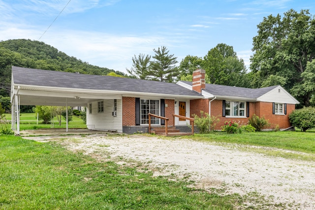 ranch-style house with a carport and a front lawn