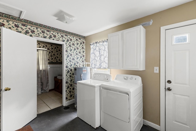 laundry room with cabinets, washer and dryer, a wealth of natural light, and dark tile patterned flooring