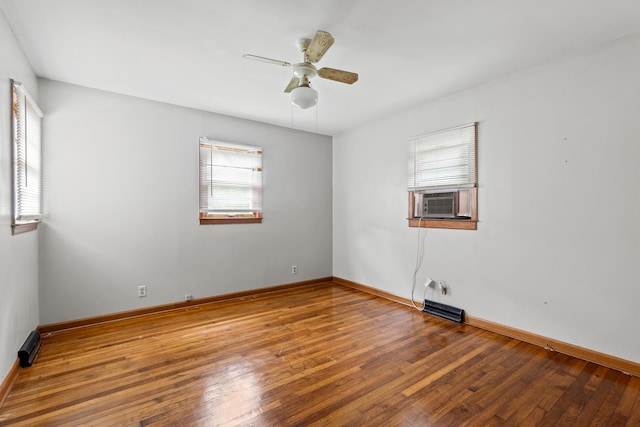 spare room featuring wood-type flooring, cooling unit, and ceiling fan