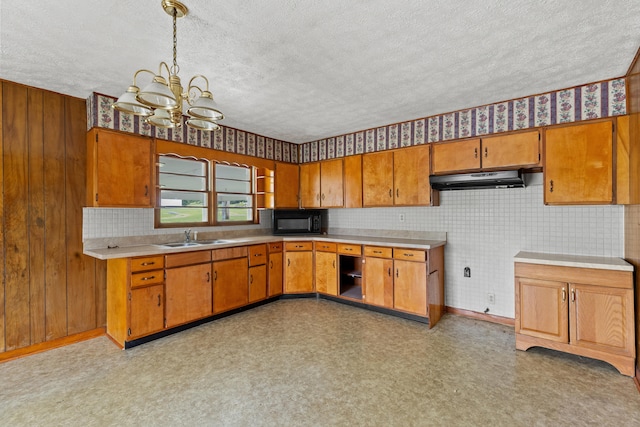 kitchen featuring pendant lighting, a notable chandelier, sink, and a textured ceiling