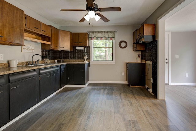 kitchen featuring sink, decorative backsplash, ceiling fan, light hardwood / wood-style floors, and extractor fan