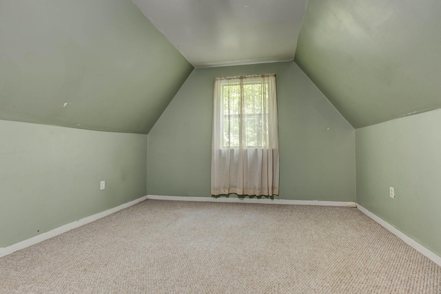 bonus room featuring lofted ceiling and light carpet