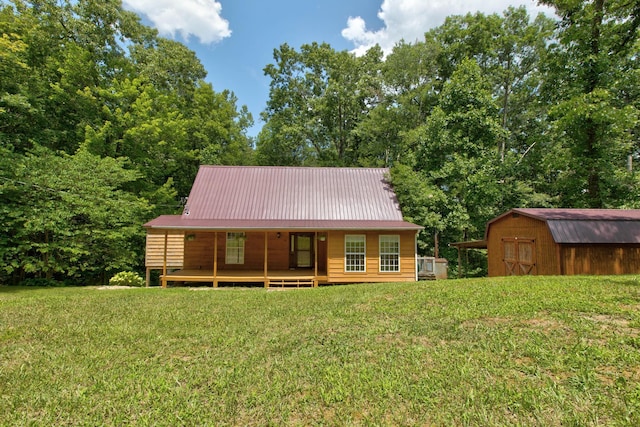 back of house with a storage unit and a lawn