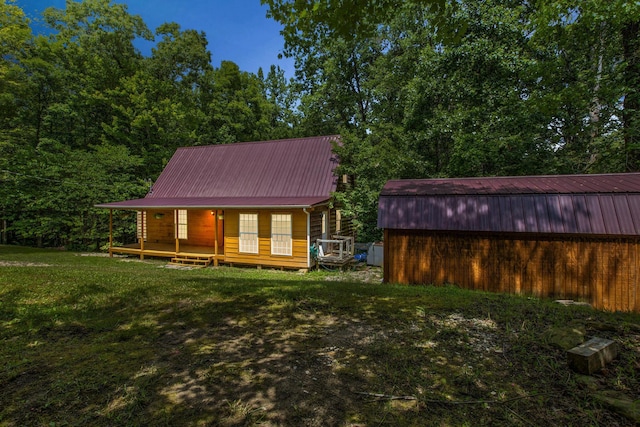 rear view of property with a porch and a lawn