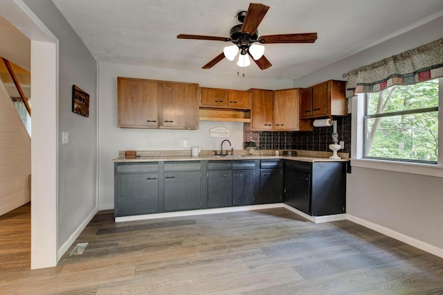 kitchen featuring ceiling fan, light hardwood / wood-style floors, sink, and tasteful backsplash