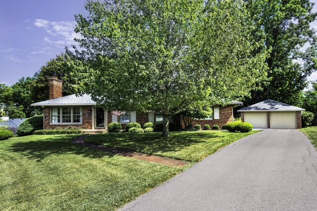 single story home featuring a garage and a front lawn