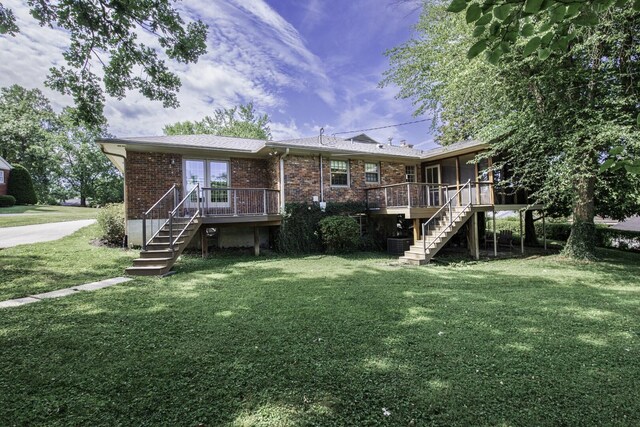 rear view of property with a wooden deck and a yard