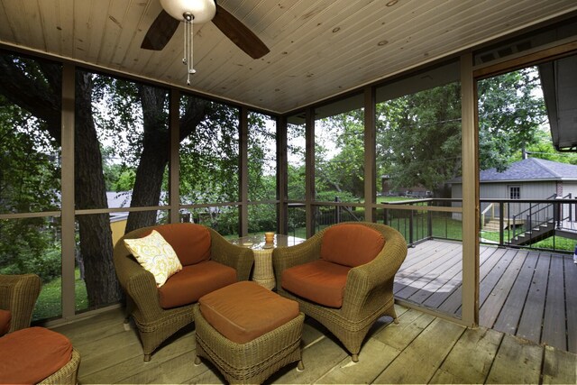 sunroom with ceiling fan and wooden ceiling