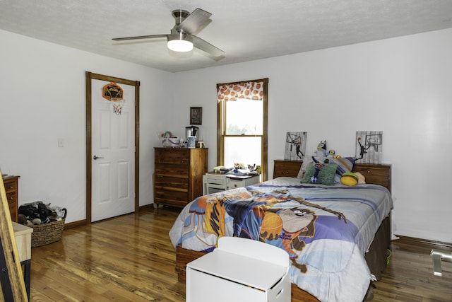 bedroom with a textured ceiling, ceiling fan, and dark hardwood / wood-style floors