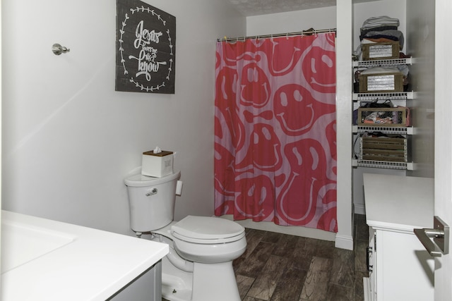 bathroom featuring a shower with shower curtain, vanity, and toilet