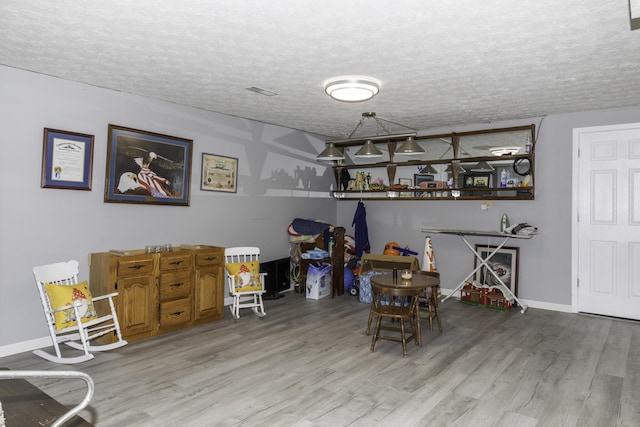 dining room featuring a textured ceiling and hardwood / wood-style flooring