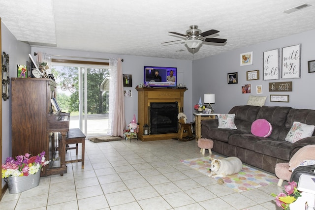 living room with light tile patterned floors, a textured ceiling, and ceiling fan