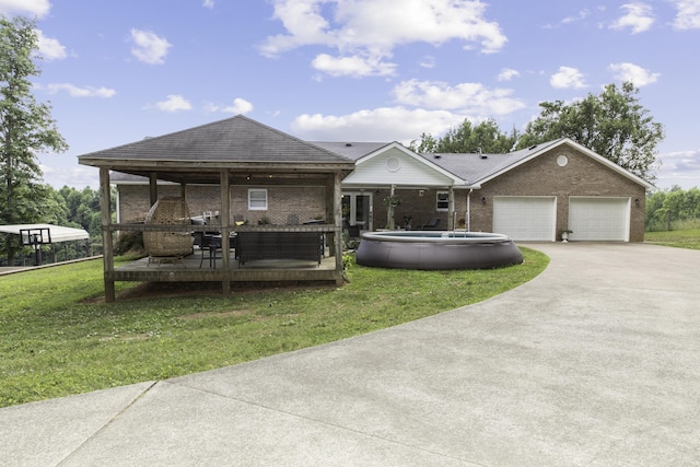 view of front of property featuring a garage, a deck, and a front yard