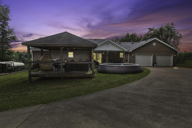 view of front facade featuring a lawn, a garage, and a deck