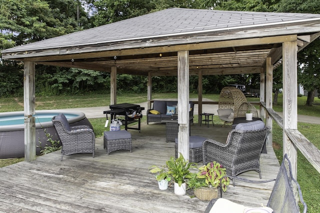 wooden terrace featuring outdoor lounge area, a gazebo, a yard, and a swimming pool