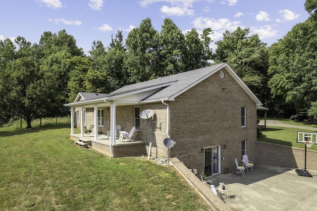 view of front of home with covered porch, a patio area, and a front yard