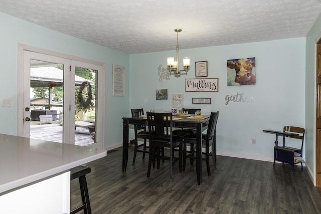 dining room featuring dark hardwood / wood-style flooring, a textured ceiling, and an inviting chandelier