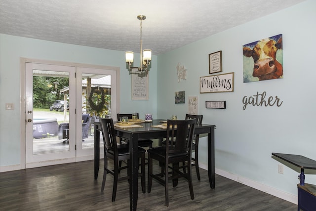 dining room featuring a chandelier, a textured ceiling, and dark wood-type flooring