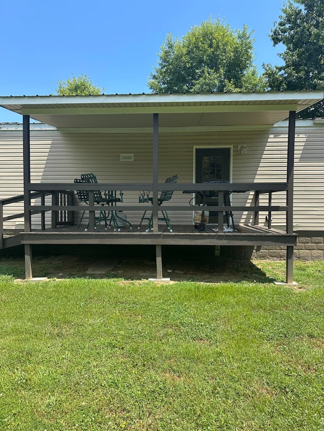 rear view of property with a lawn and a wooden deck