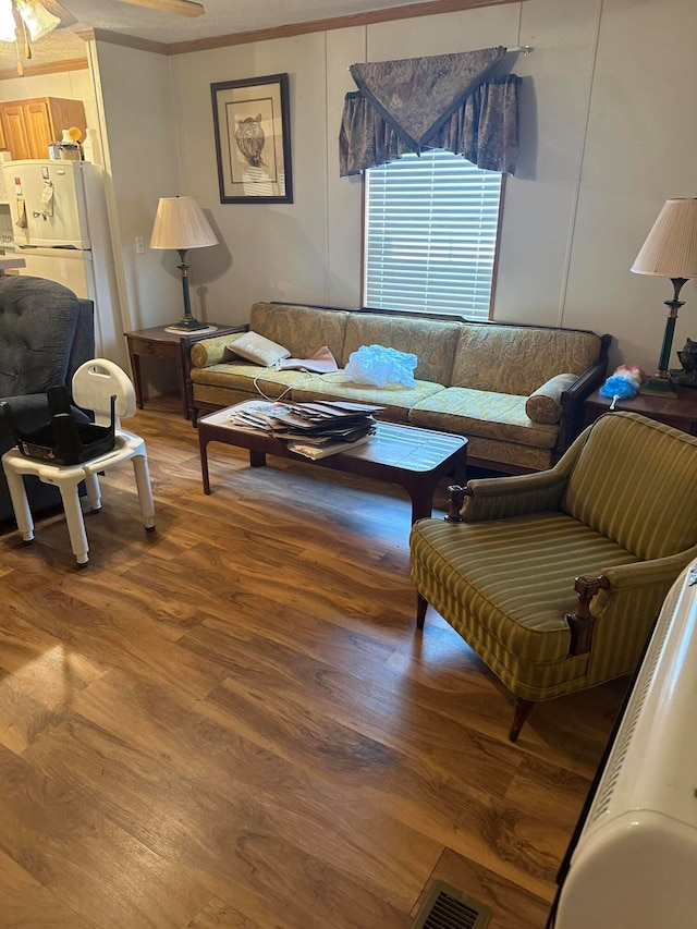 living room with ornamental molding and wood-type flooring