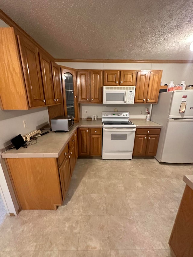 kitchen with crown molding, white appliances, light tile patterned floors, and a textured ceiling