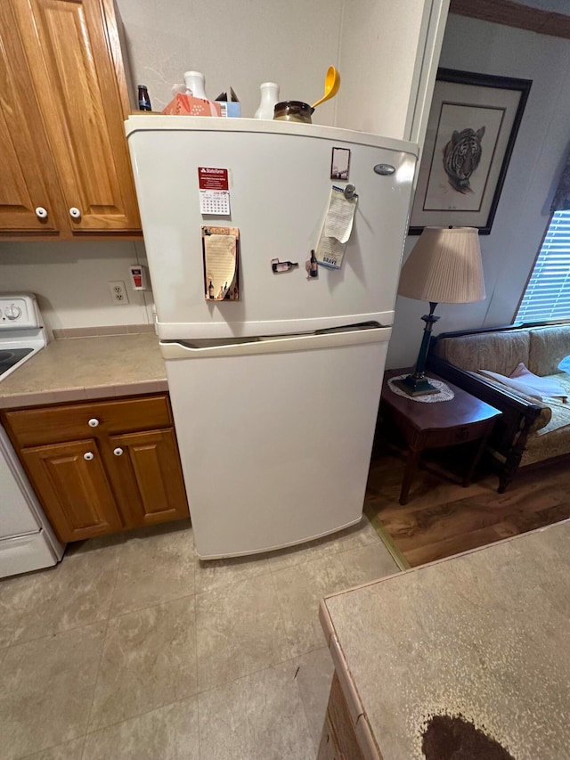 kitchen featuring range, white fridge, and light tile patterned floors