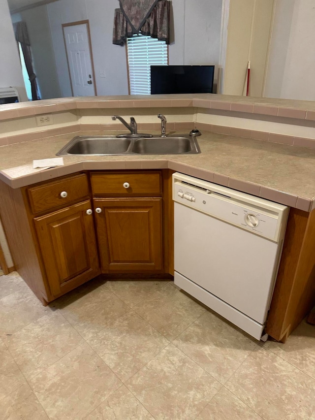 kitchen with sink, white dishwasher, and light tile patterned floors