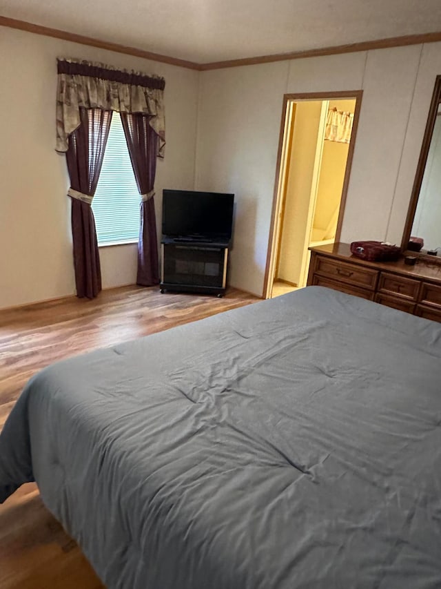 bedroom featuring wood-type flooring and ornamental molding