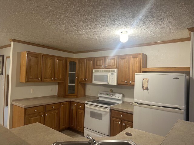 kitchen featuring ornamental molding, a textured ceiling, and white appliances