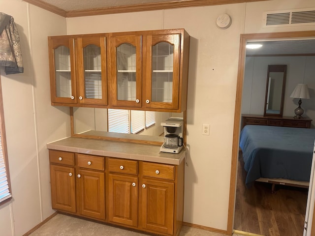 kitchen featuring light hardwood / wood-style floors and crown molding