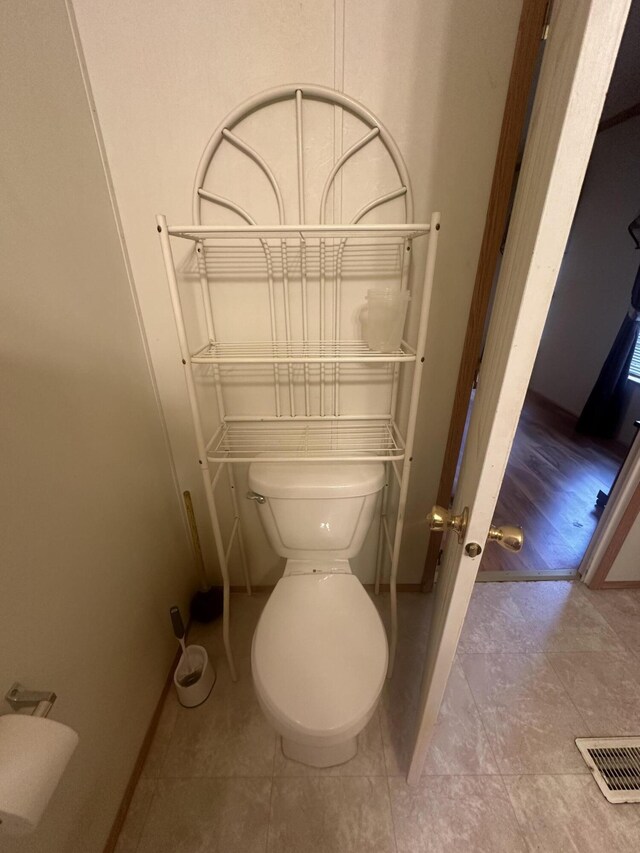 bathroom with toilet and hardwood / wood-style flooring