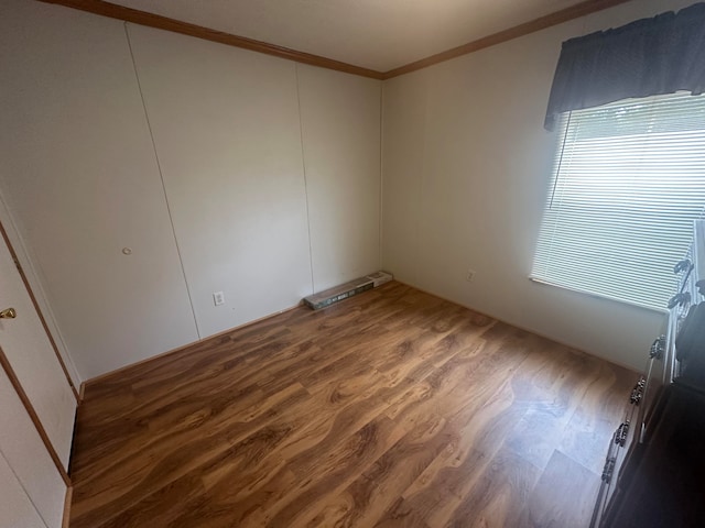 spare room with crown molding and hardwood / wood-style floors