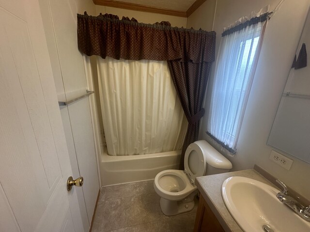 full bathroom featuring shower / bath combo with shower curtain, tile patterned floors, toilet, vanity, and ornamental molding