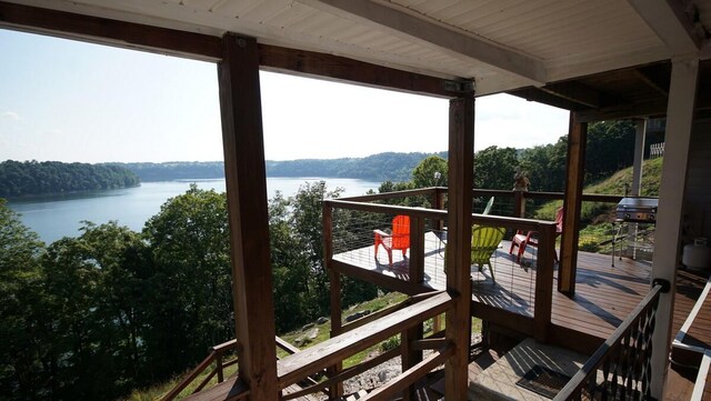 view of dock with a balcony and a water view