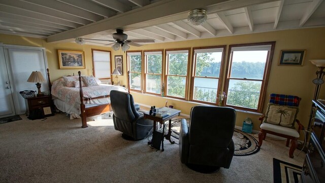 carpeted bedroom featuring beamed ceiling and ceiling fan