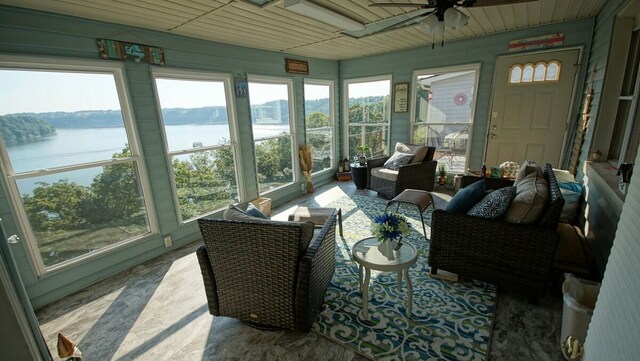 sunroom / solarium featuring a water view, ceiling fan, and a wealth of natural light