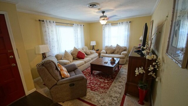 carpeted living room with a textured ceiling, ornamental molding, and ceiling fan