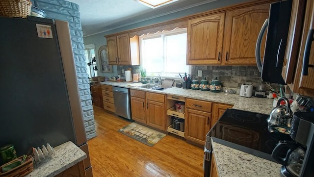 kitchen featuring crown molding, stainless steel appliances, light hardwood / wood-style flooring, and tasteful backsplash