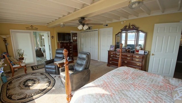 carpeted bedroom featuring beam ceiling, multiple closets, and ceiling fan