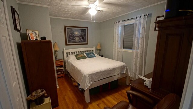 bedroom with ceiling fan, crown molding, a textured ceiling, and hardwood / wood-style flooring