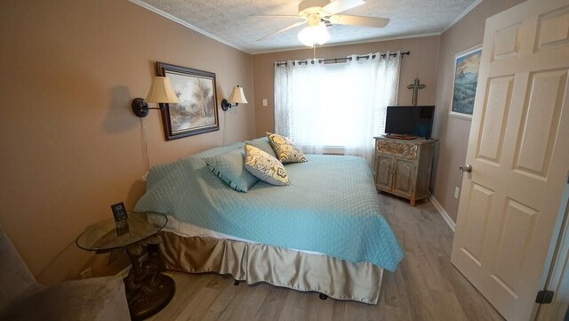 bedroom featuring light hardwood / wood-style floors, ornamental molding, and ceiling fan