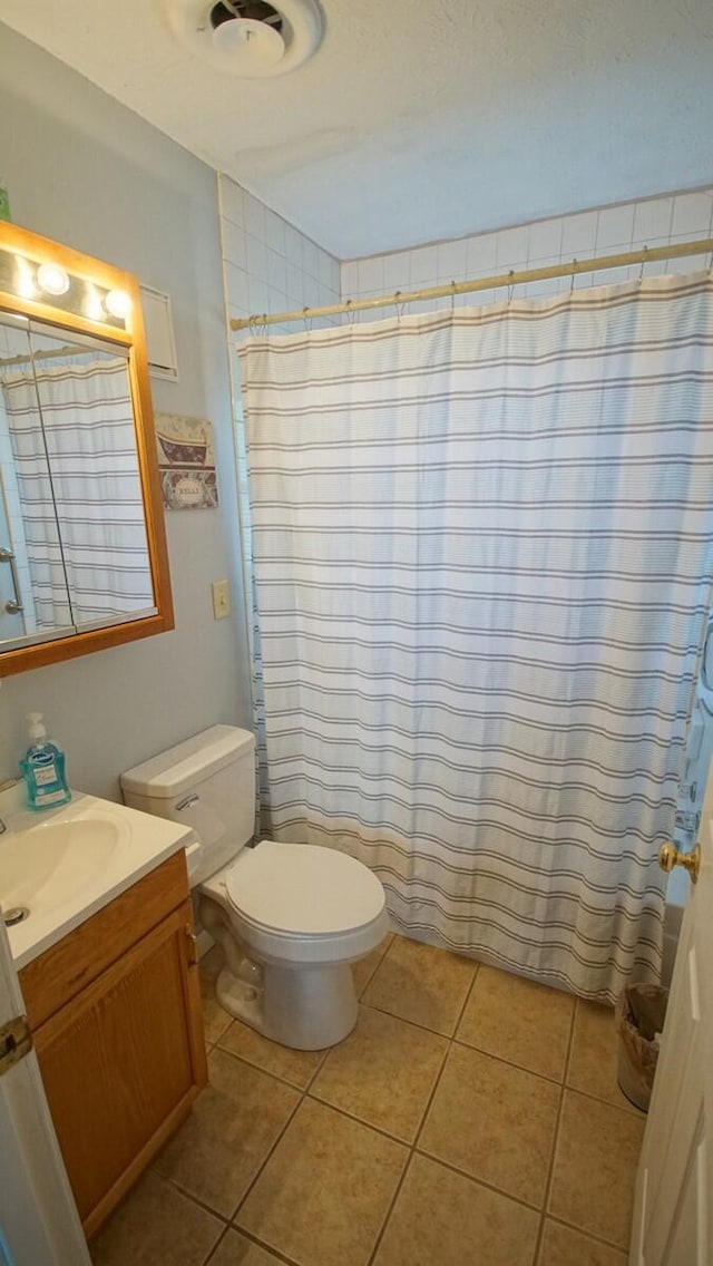 bathroom featuring tile patterned flooring, toilet, and vanity