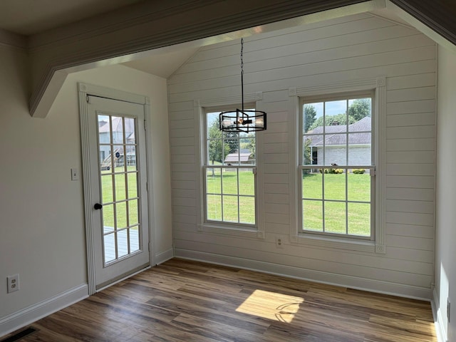 doorway to outside featuring vaulted ceiling, a chandelier, and dark hardwood / wood-style flooring