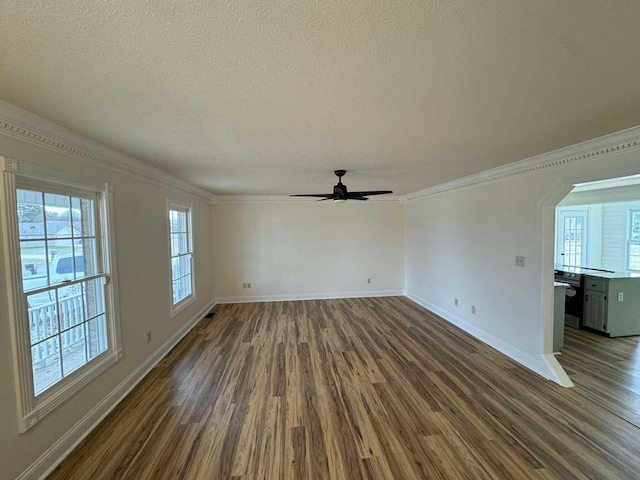 unfurnished living room with ceiling fan, dark wood-type flooring, crown molding, and a textured ceiling