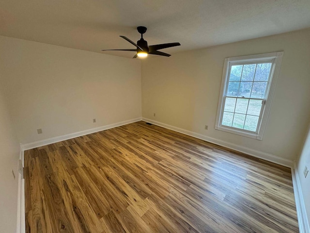 empty room with ceiling fan and light hardwood / wood-style floors