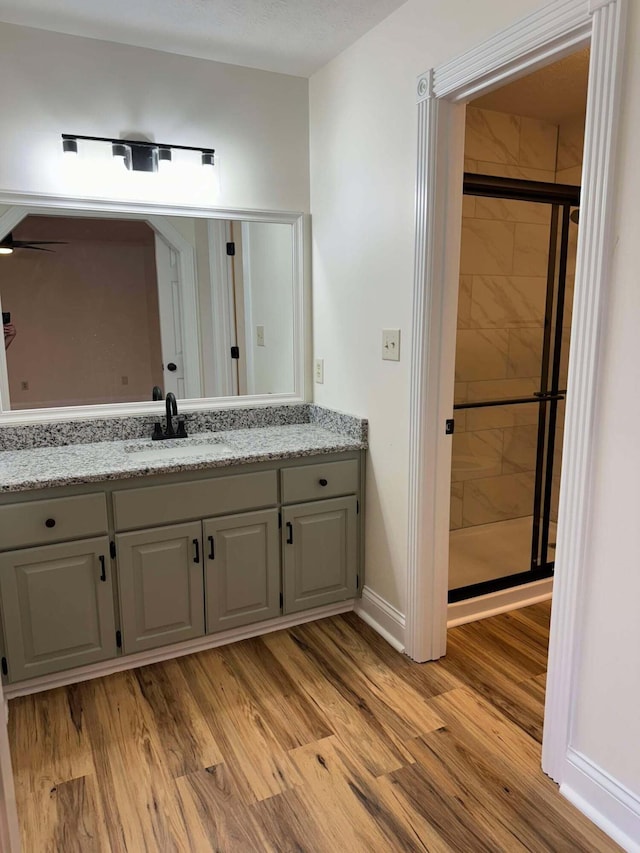 bathroom with vanity, hardwood / wood-style flooring, and walk in shower