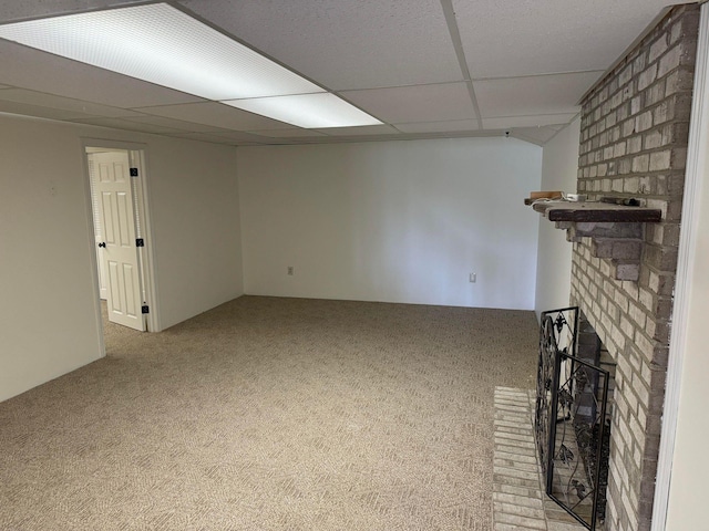 unfurnished living room featuring a paneled ceiling, a fireplace, and light carpet